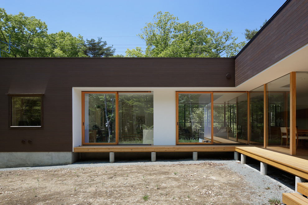 Immagine della villa multicolore moderna a un piano con rivestimento in legno, tetto a capanna e copertura in metallo o lamiera