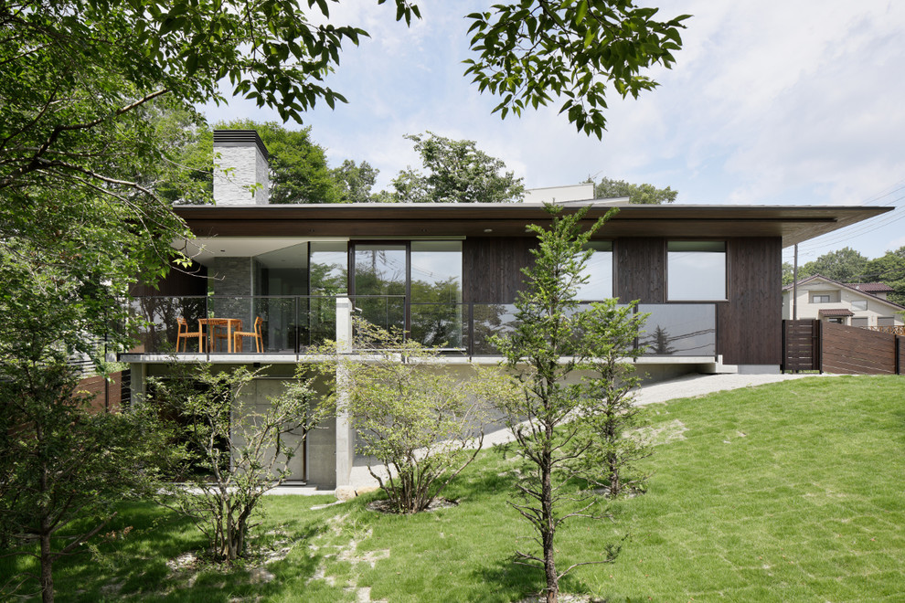 Idée de décoration pour une façade de maison marron minimaliste en bois à un étage avec un toit à quatre pans et un toit en métal.