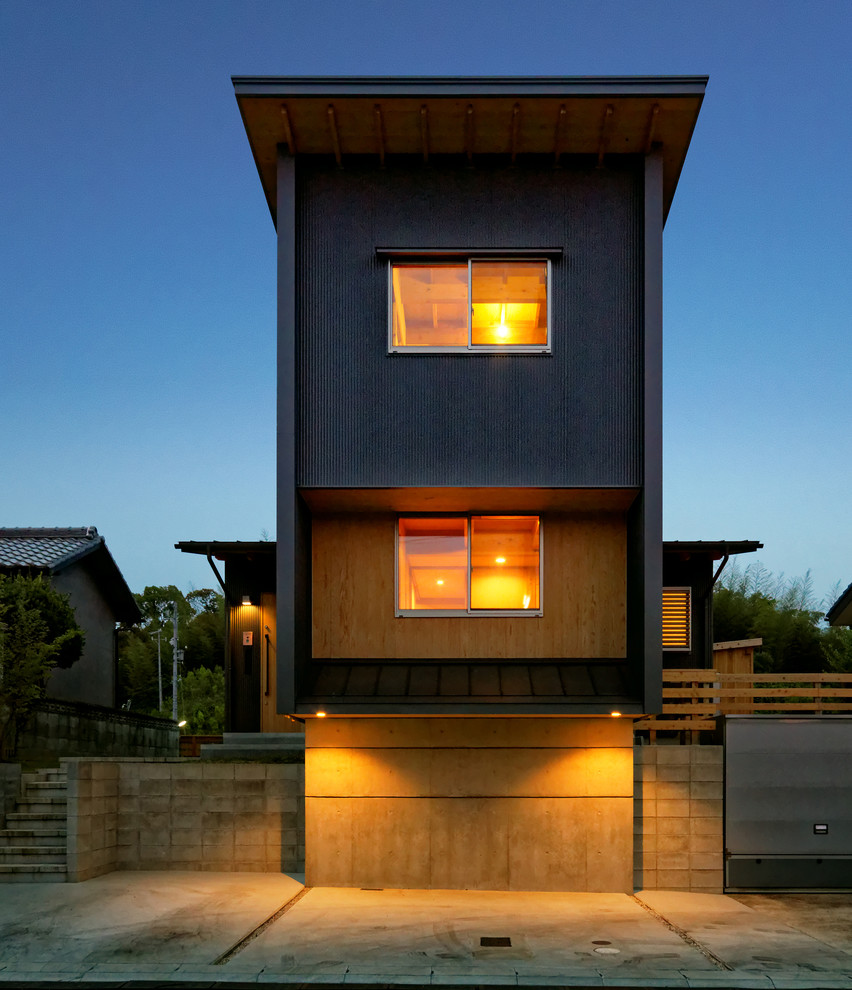 Пример оригинального дизайна: двухэтажный, черный, маленький частный загородный дом в стиле модернизм с облицовкой из металла, односкатной крышей и металлической крышей для на участке и в саду