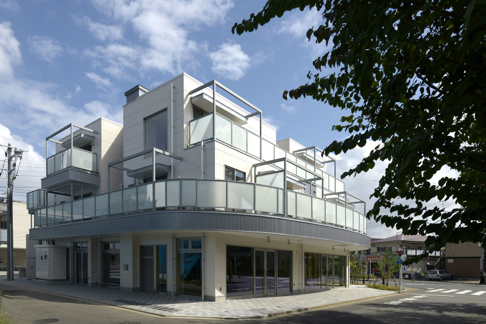 Foto della facciata di un appartamento grande beige industriale a tre piani con rivestimenti misti, tetto piano e copertura in metallo o lamiera