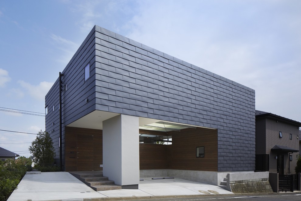 Cette photo montre une façade de maison grise tendance avec un toit plat.