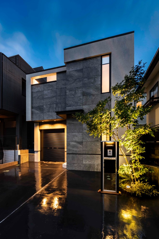 Cette image montre une façade de maison grise minimaliste de taille moyenne et à un étage avec un toit en appentis et un toit en métal.