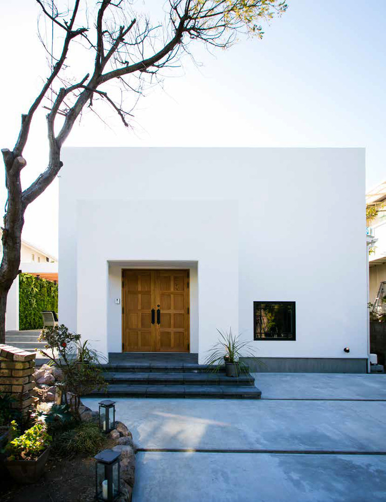 Стильный дизайн: одноэтажный, белый частный загородный дом в восточном стиле с облицовкой из цементной штукатурки и плоской крышей - последний тренд