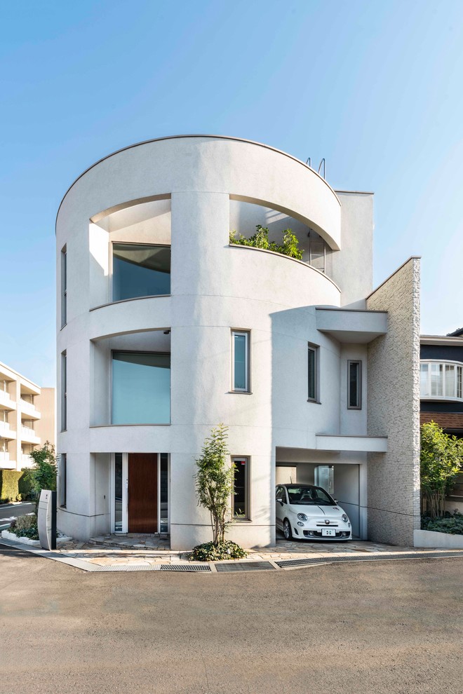 Inspiration pour une grande façade de maison blanche minimaliste à deux étages et plus avec un toit en métal.