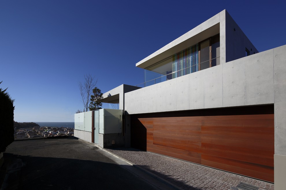 На фото: большой, двухэтажный, серый дом в современном стиле с облицовкой из бетона и плоской крышей