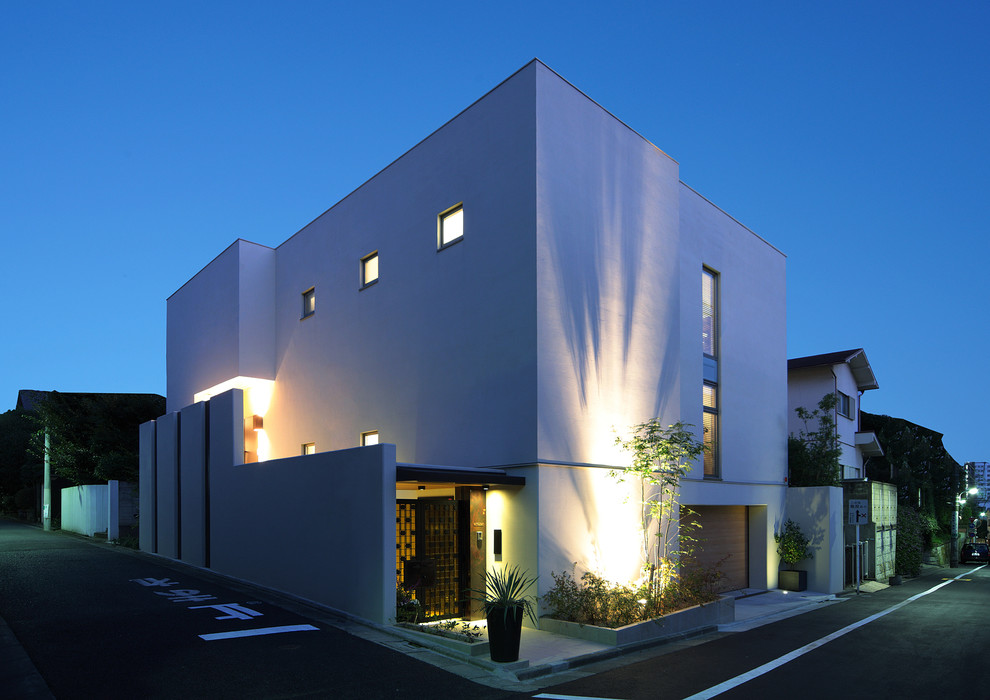 Large and white modern two floor detached house in Tokyo with a lean-to roof.