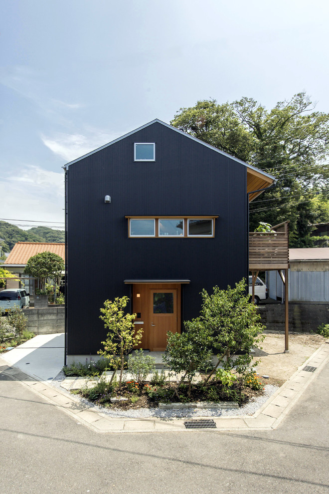 Photo of a medium sized and black scandi house exterior in Other with a pitched roof.