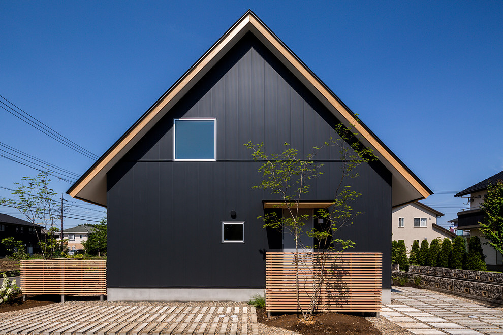 Aménagement d'une façade de maison noire asiatique avec un toit à deux pans.