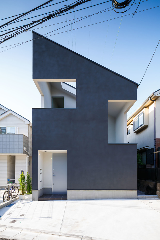 Modernes Haus mit schwarzer Fassadenfarbe und Pultdach in Tokio