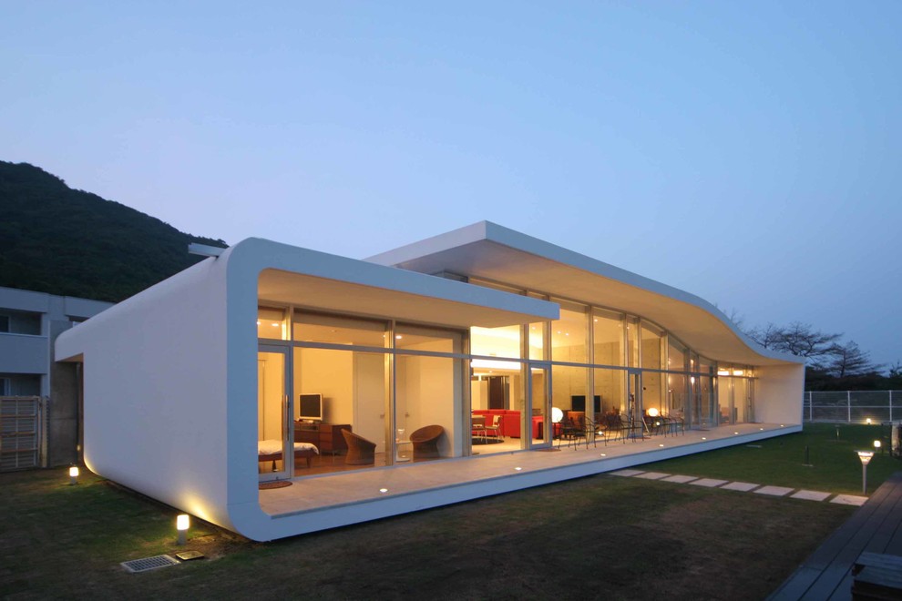 На фото: одноэтажный, белый дом в современном стиле с облицовкой из бетона и плоской крышей