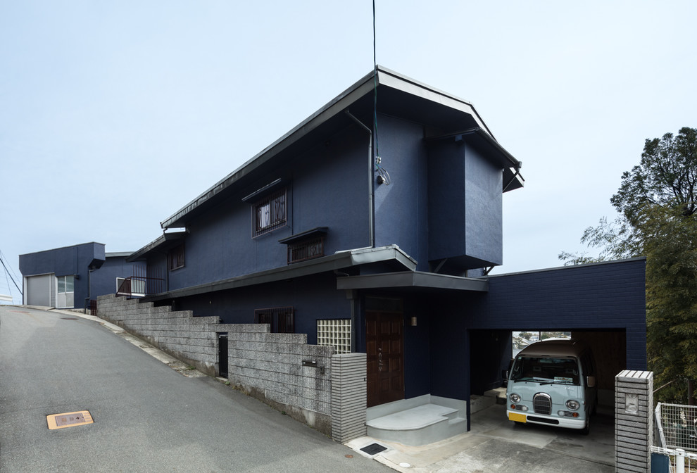 Immagine della facciata di una casa blu contemporanea con tetto a capanna