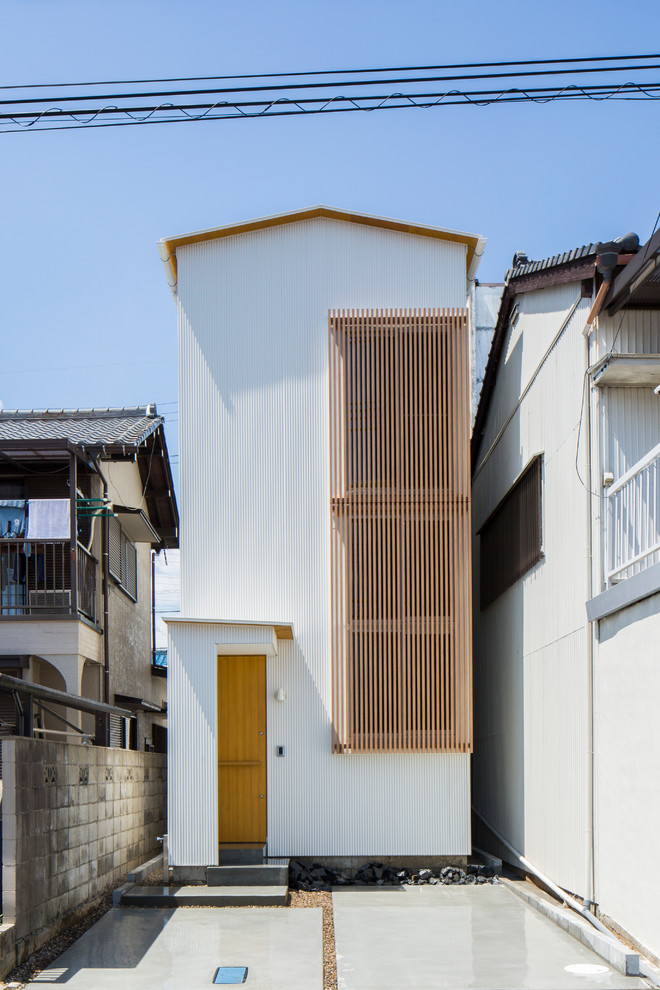 Foto de fachada de casa blanca de estilo zen pequeña a niveles con revestimiento de metal, tejado a dos aguas y tejado de metal