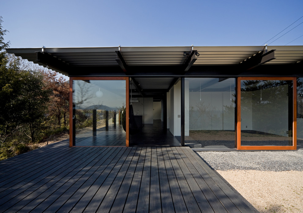 Idée de décoration pour une façade de maison noire minimaliste de plain-pied avec un revêtement mixte et un toit plat.