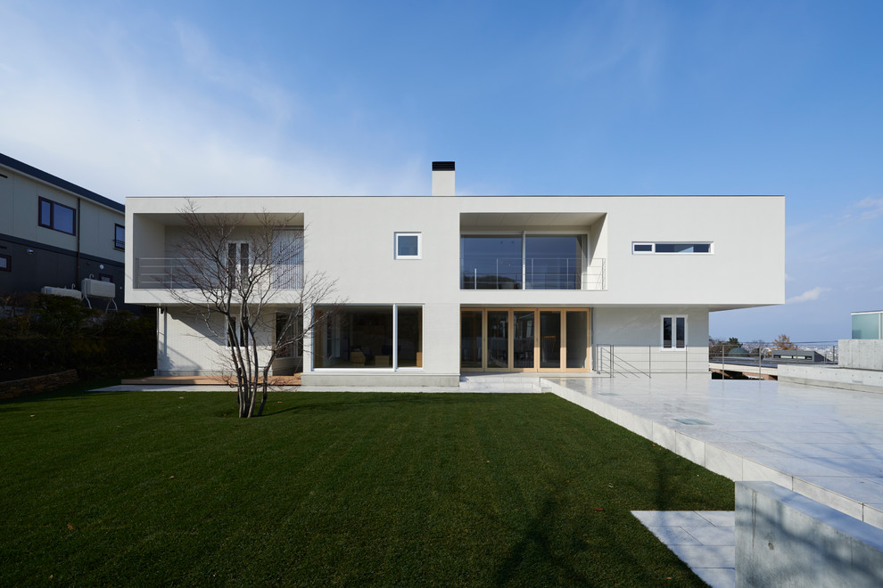 На фото: трехэтажный, белый частный загородный дом в скандинавском стиле с плоской крышей с