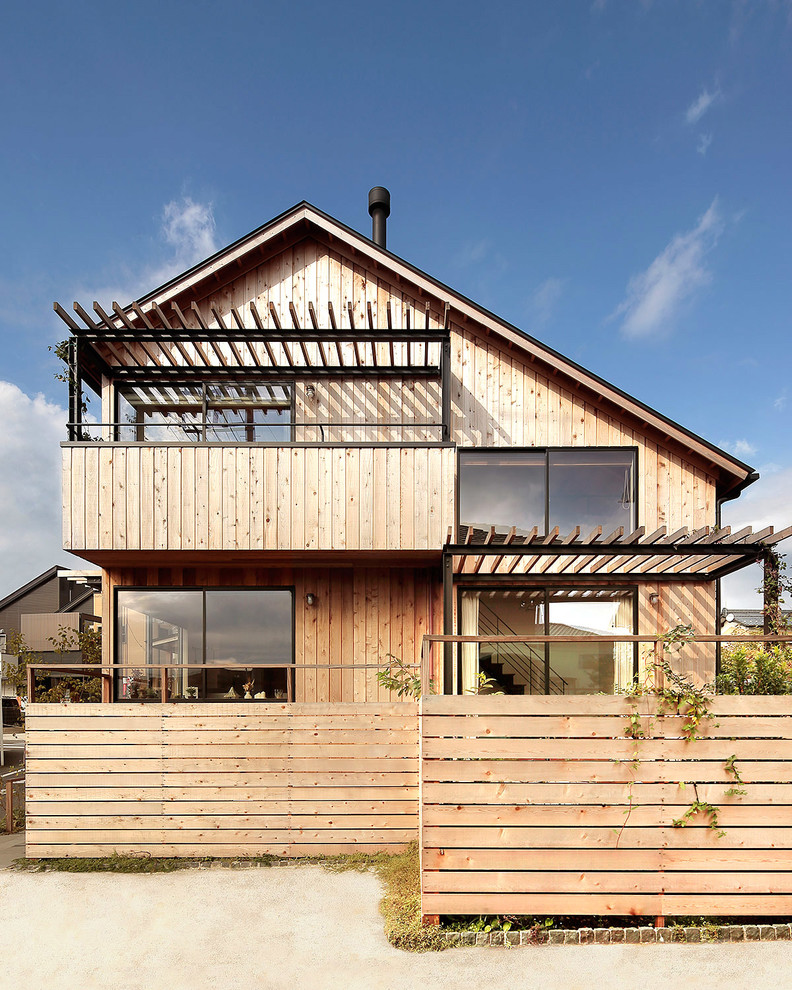 Inspiration pour une façade de maison beige asiatique en bois à un étage avec un toit à deux pans.