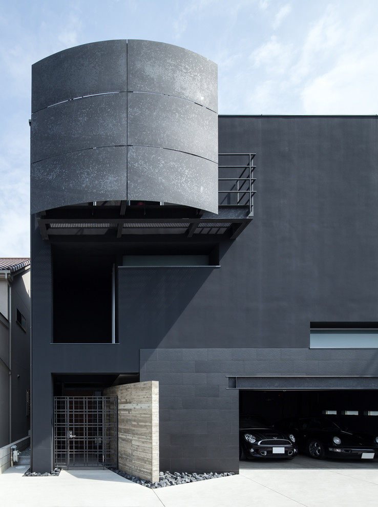 Réalisation d'une façade de maison noire design avec un toit plat.
