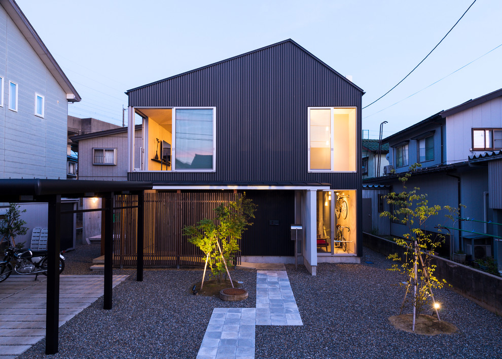 Стильный дизайн: двухэтажный, черный дом среднего размера в стиле модернизм с двускатной крышей и комбинированной облицовкой - последний тренд