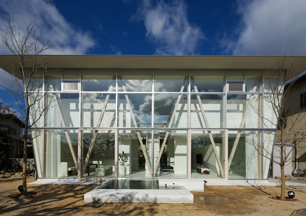 Источник вдохновения для домашнего уюта: стеклянный, белый дом в стиле модернизм с разными уровнями и плоской крышей