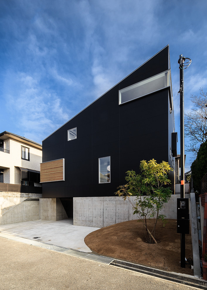 This is an example of a contemporary house exterior in Kobe with three floors, mixed cladding and a lean-to roof.