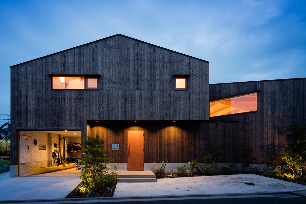 Стильный дизайн: двухэтажный, деревянный, коричневый частный загородный дом в морском стиле с двускатной крышей и металлической крышей - последний тренд