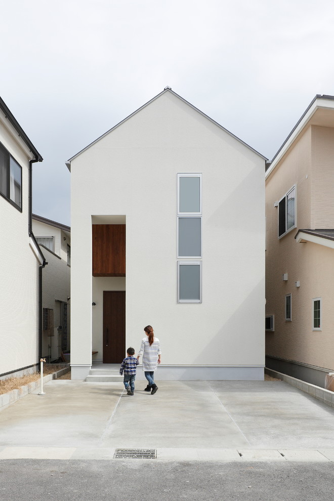 Réalisation d'une petite façade de maison blanche chalet en béton à un étage avec un toit à deux pans et un toit en métal.