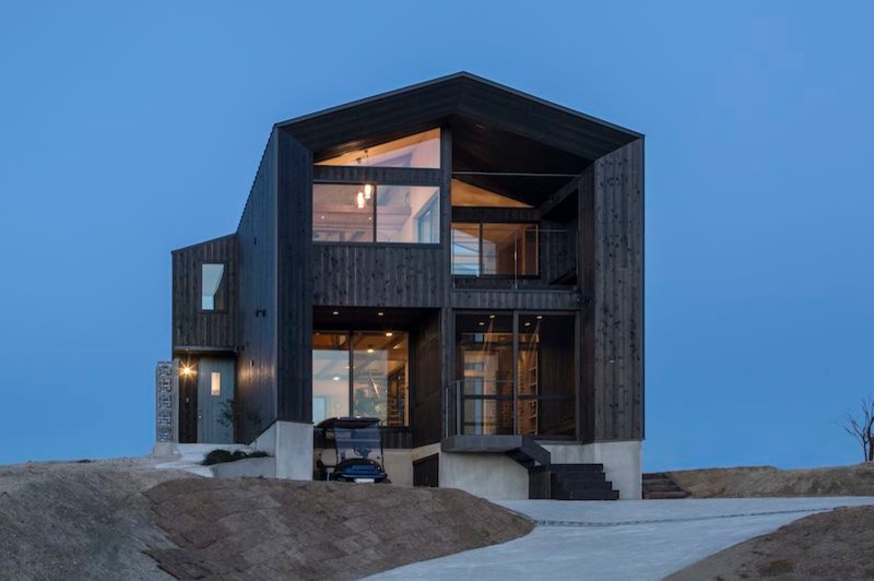 Idées déco pour une façade de maison noire rétro en bois de taille moyenne et à un étage avec un toit à deux pans et un toit en métal.