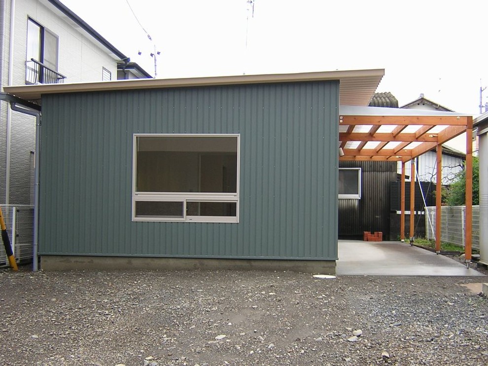На фото: маленький, одноэтажный, зеленый дом в стиле лофт с односкатной крышей и металлической крышей для на участке и в саду