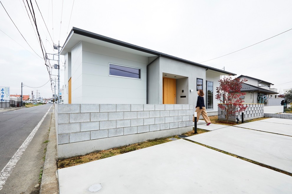 Ispirazione per la facciata di una casa grigia moderna a due piani di medie dimensioni con rivestimento in cemento e copertura in metallo o lamiera