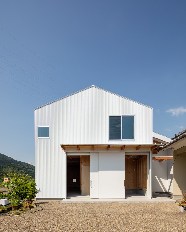 Cette photo montre une façade de maison blanche asiatique avec un toit à deux pans.
