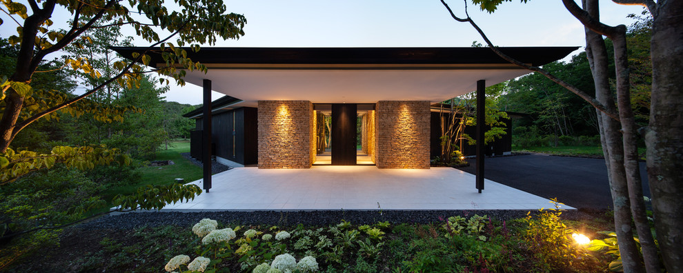 Einstöckiges Modernes Haus mit Mix-Fassade, schwarzer Fassadenfarbe und Flachdach in Sonstige