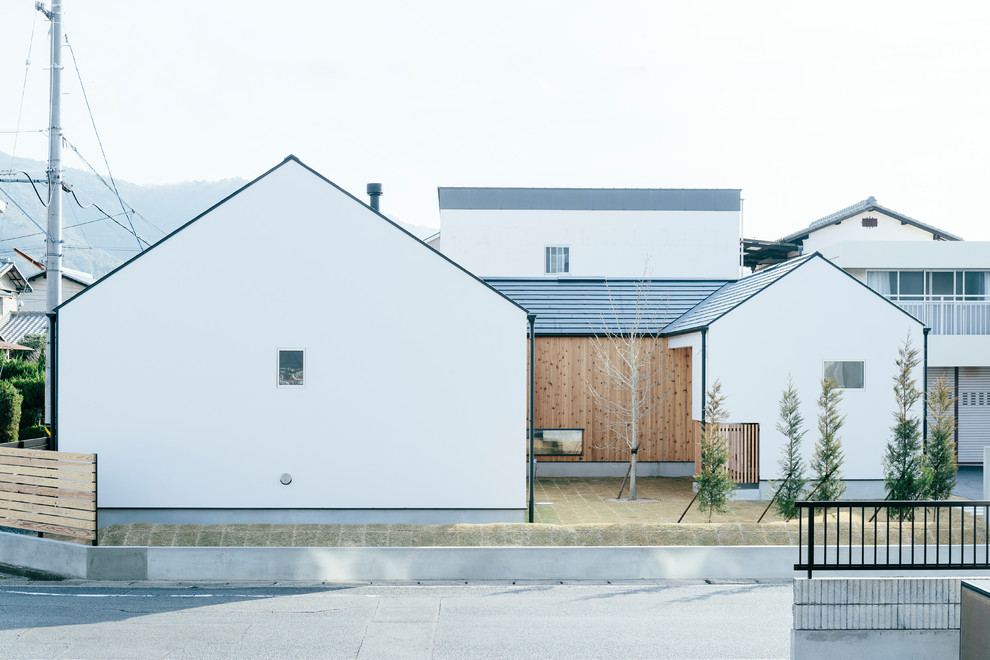 This is an example of a white world-inspired house exterior in Other with a pitched roof.