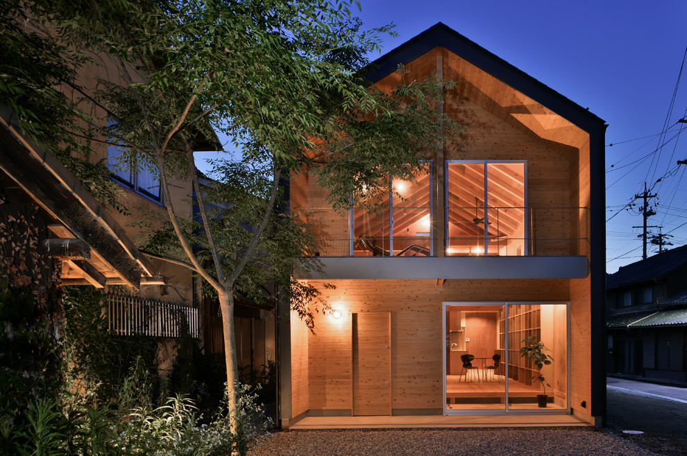 Idée de décoration pour une façade de maison marron asiatique en bois avec un toit à deux pans.