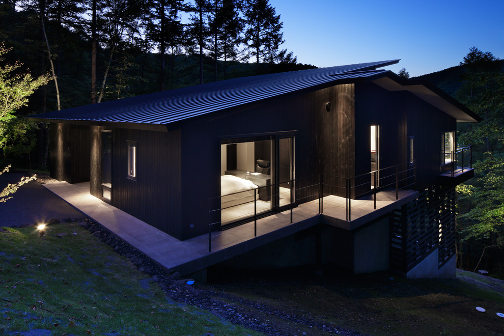 Imagen de fachada marrón moderna con revestimiento de madera y tejado a dos aguas
