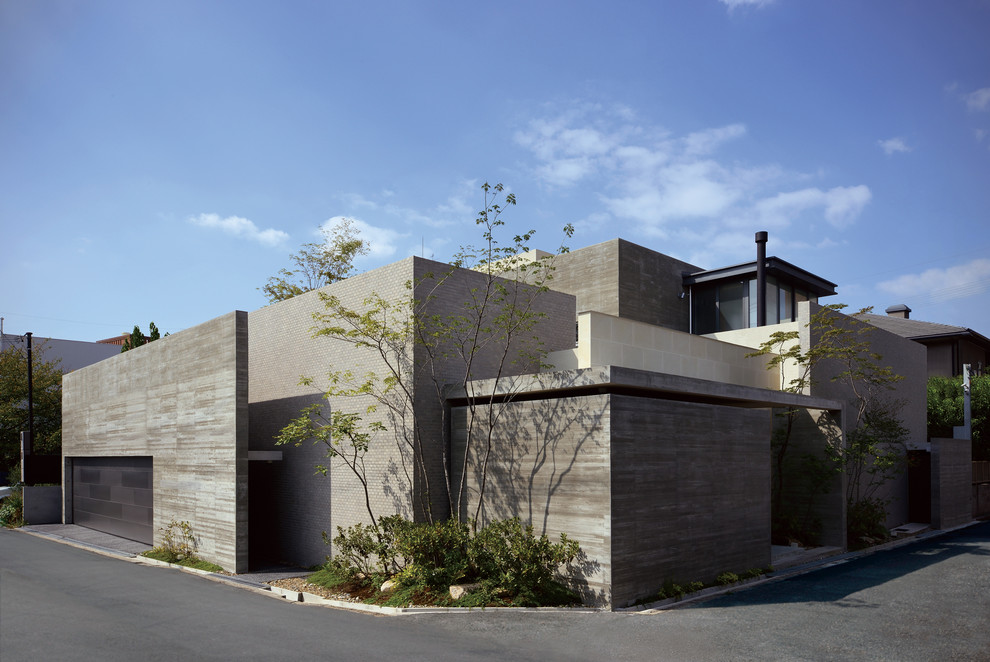 Cette image montre une grande façade de maison grise design avec un revêtement mixte et un toit plat.