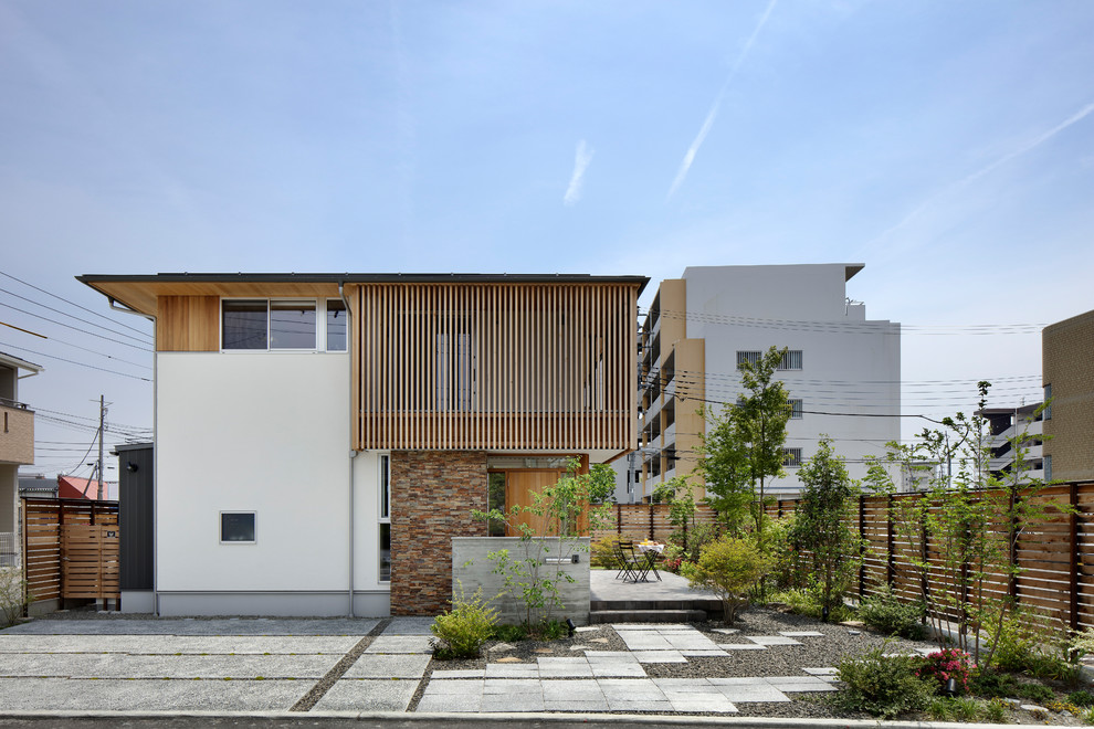 Idée de décoration pour une façade de maison multicolore asiatique avec un toit plat.