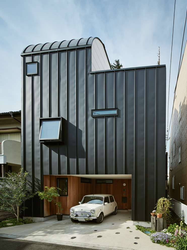 Idées déco pour une façade de maison noire contemporaine.