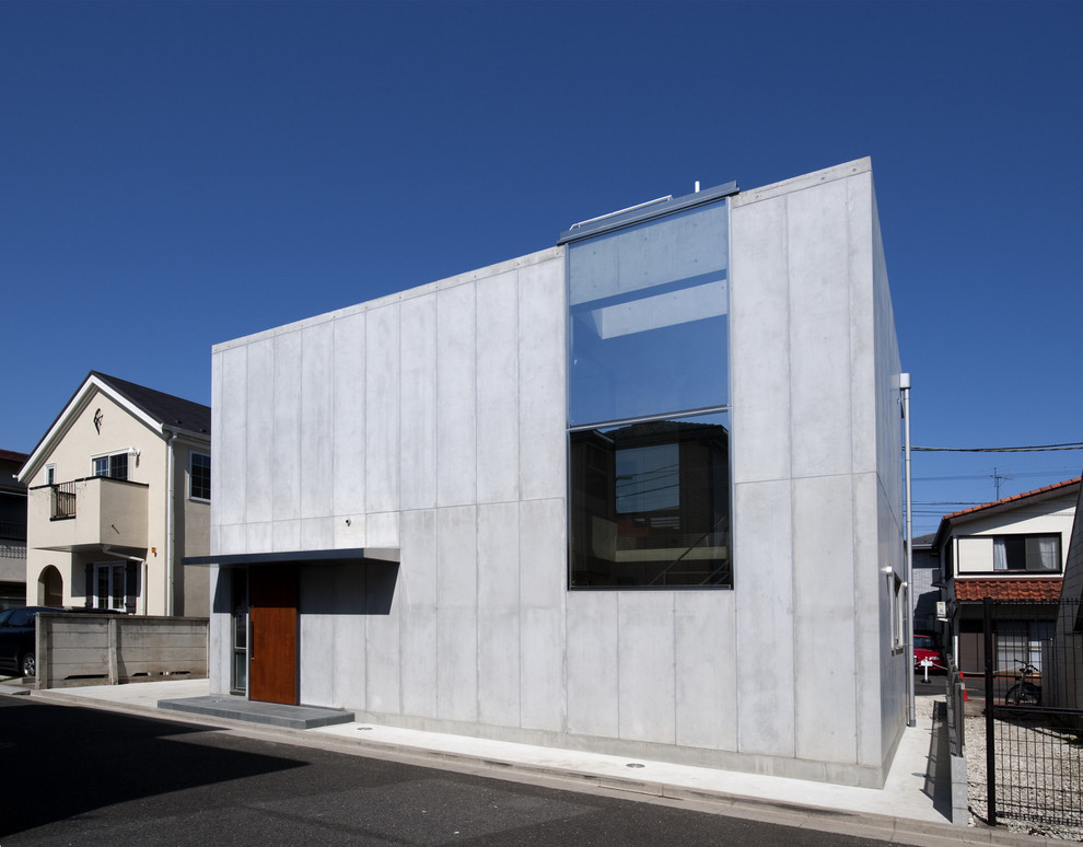 Idee per la facciata di una casa grigia contemporanea a due piani con rivestimento in cemento e tetto piano