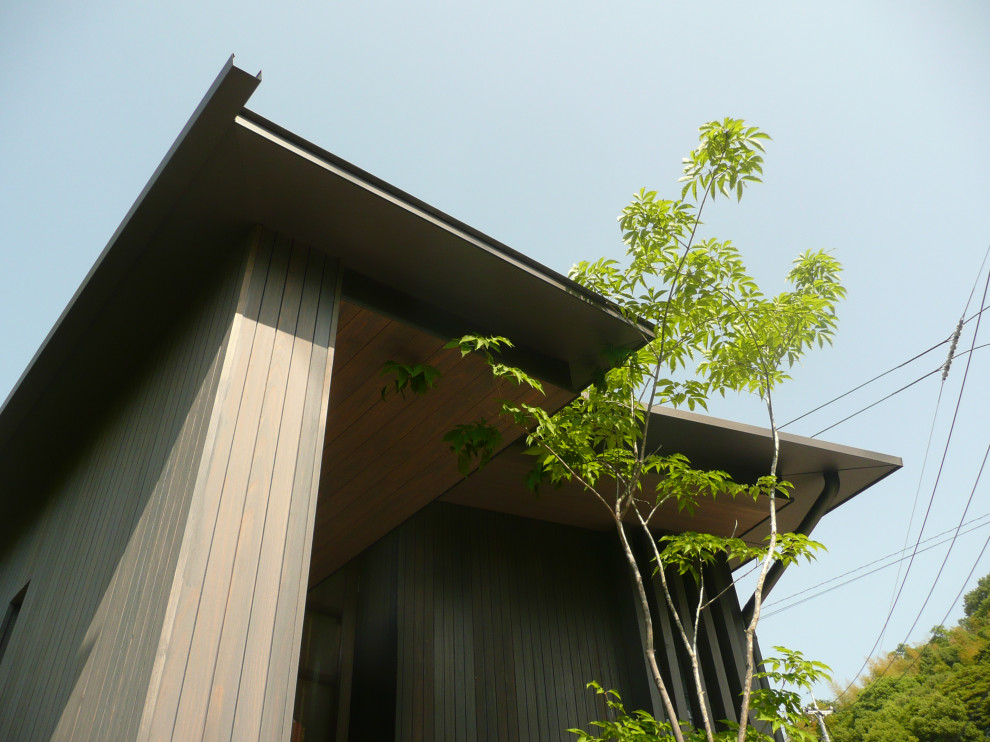 Diseño de fachada marrón retro pequeña de una planta con revestimiento de madera, tejado a dos aguas, microcasa y tejado de metal