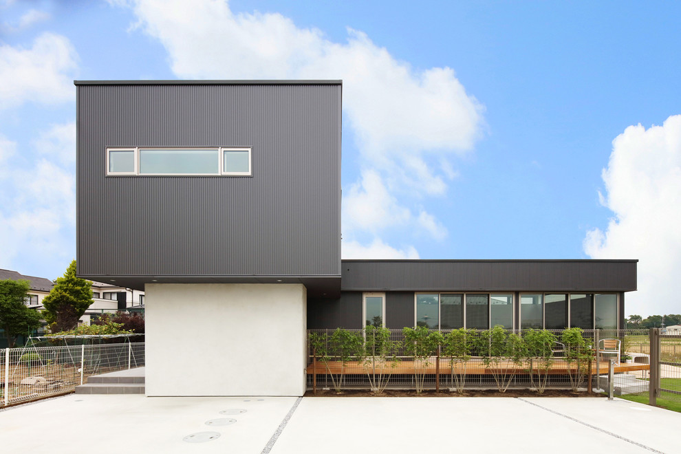 Ejemplo de fachada negra minimalista con tejado plano