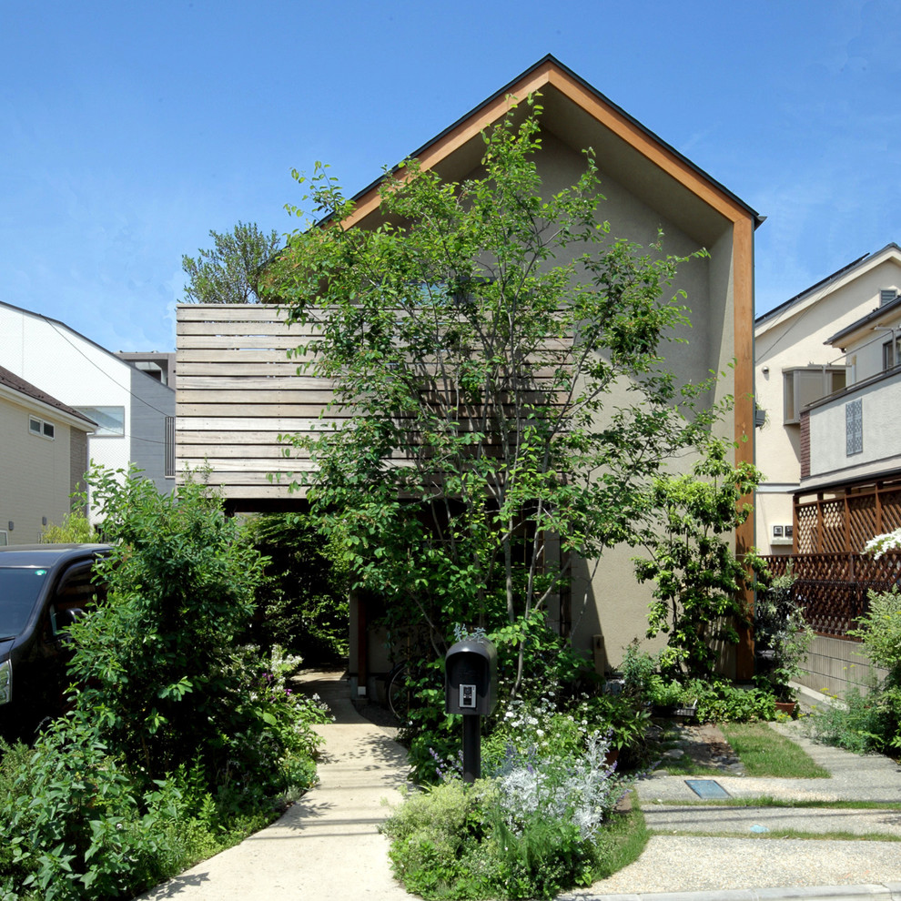 Cette photo montre une façade de maison marron asiatique avec un toit à deux pans et boîte aux lettres.