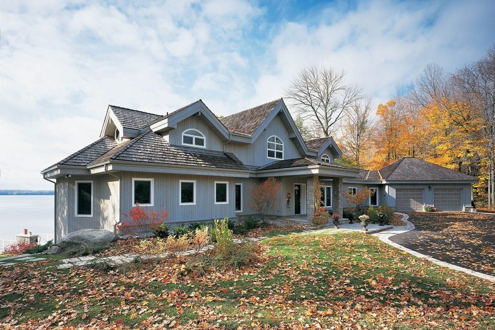 Réalisation d'une façade de maison grise tradition en bois à un étage avec un toit à quatre pans.