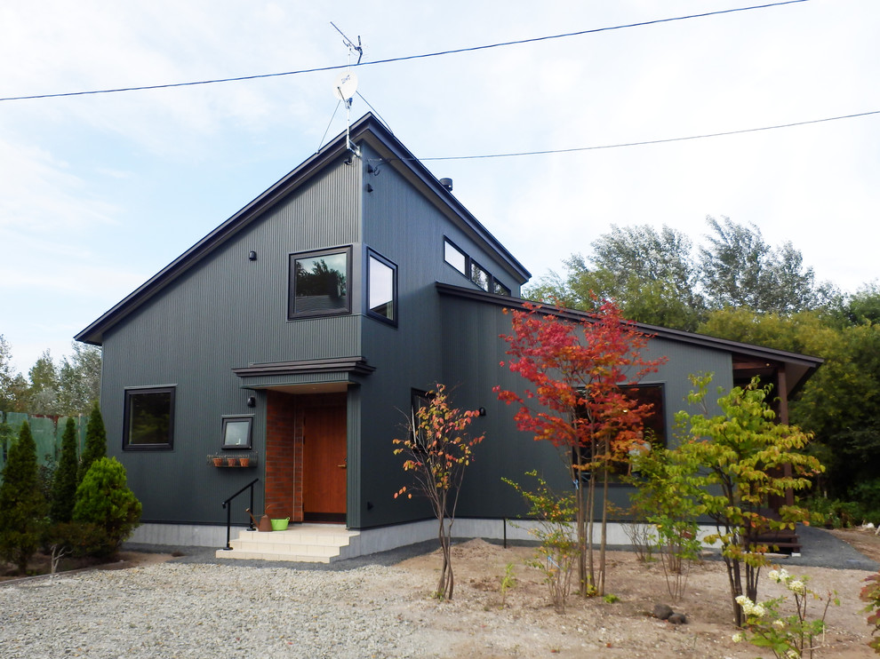 Inspiration pour une façade de maison noire design avec un toit en appentis.