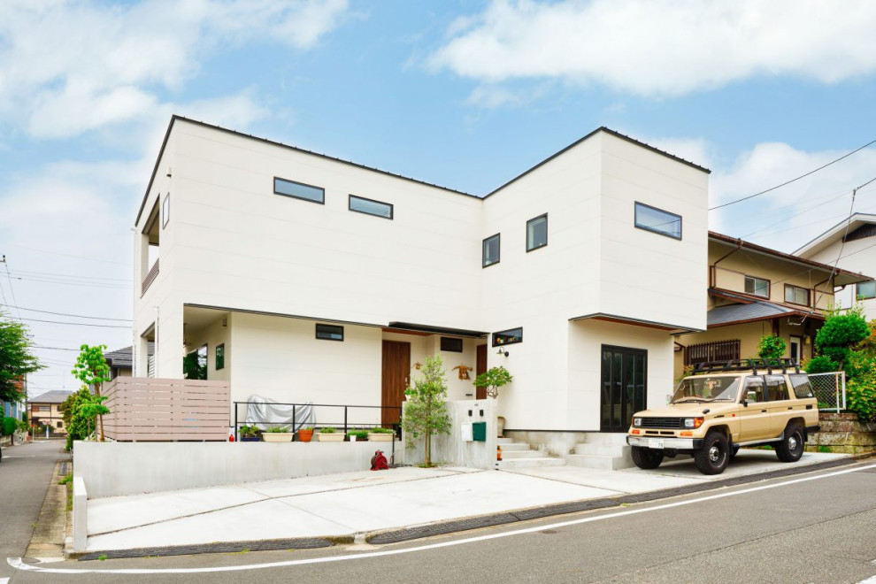 Diseño de fachada de casa blanca industrial de tamaño medio de dos plantas con revestimientos combinados, tejado plano y tejado de metal