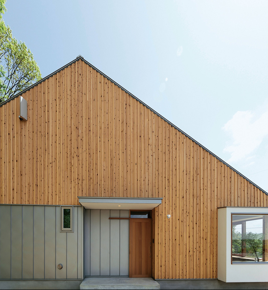 Идея дизайна: двухэтажный, коричневый частный загородный дом в восточном стиле с двускатной крышей