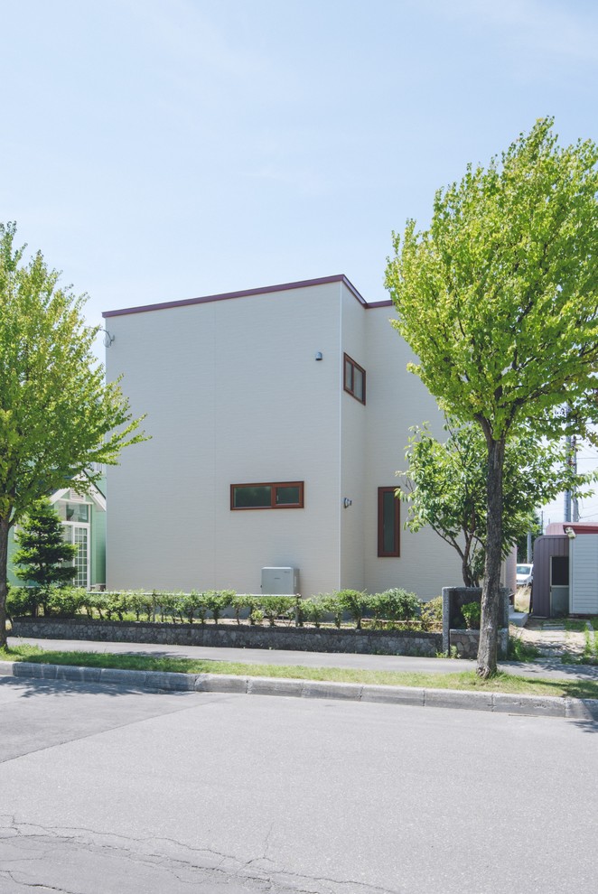 Zweistöckiges Nordisches Haus mit weißer Fassadenfarbe und Flachdach in Sapporo