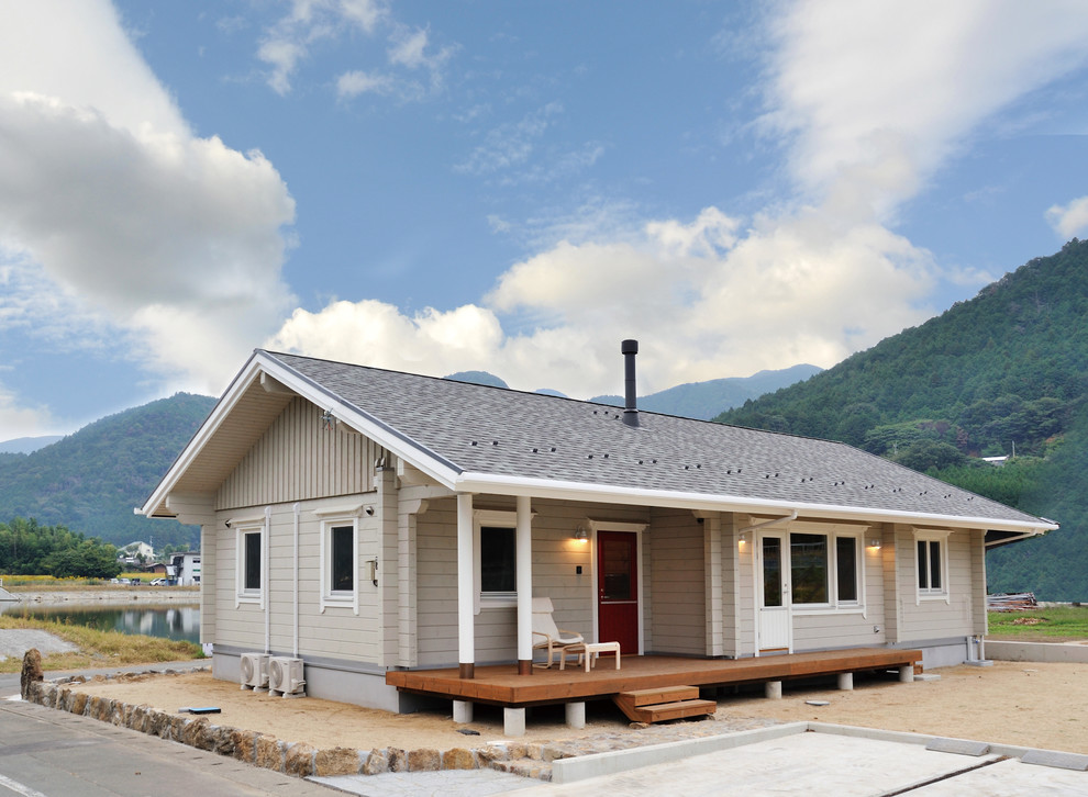 Пример оригинального дизайна: одноэтажный, серый дом из бревен в скандинавском стиле с двускатной крышей
