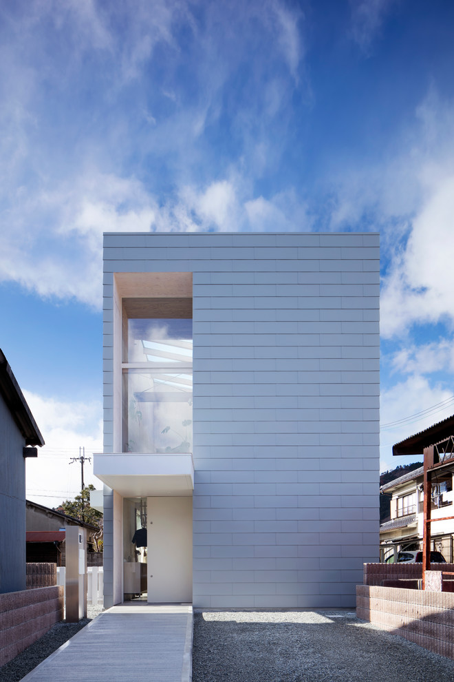 Стильный дизайн: двухэтажный, белый частный загородный дом среднего размера в стиле модернизм с плоской крышей, облицовкой из металла и крышей из гибкой черепицы - последний тренд