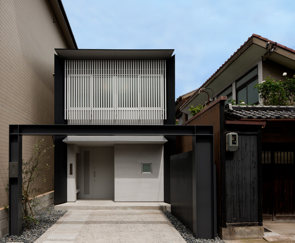 Aménagement d'une façade de maison blanche asiatique à un étage avec un revêtement mixte et un toit plat.