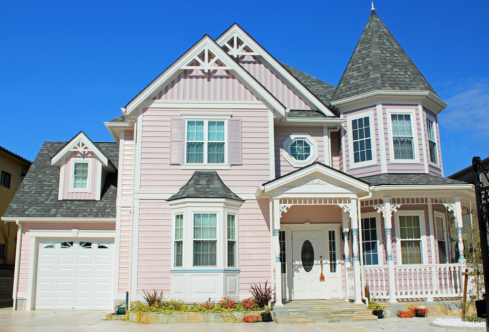 他の地域にあるヴィクトリアン調のおしゃれな二階建ての家 (混合材サイディング、ピンクの外壁) の写真