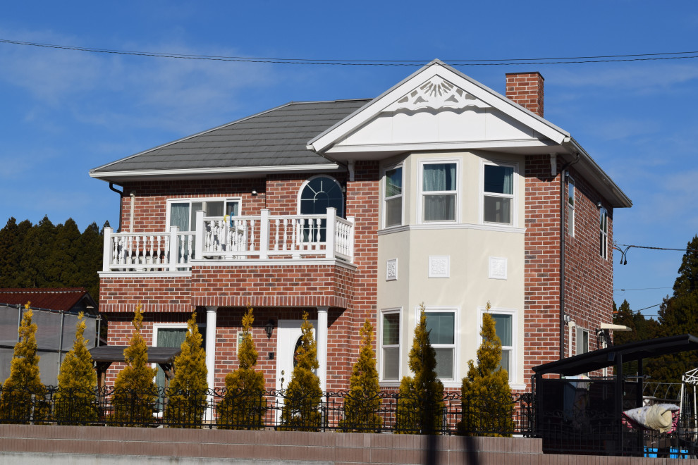 Стильный дизайн: двухэтажный, кирпичный, красный частный загородный дом среднего размера в викторианском стиле с вальмовой крышей и металлической крышей - последний тренд